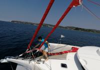 ragazza rimuovendo gennaker dalla prua della barca a vela trimarano neel 45
